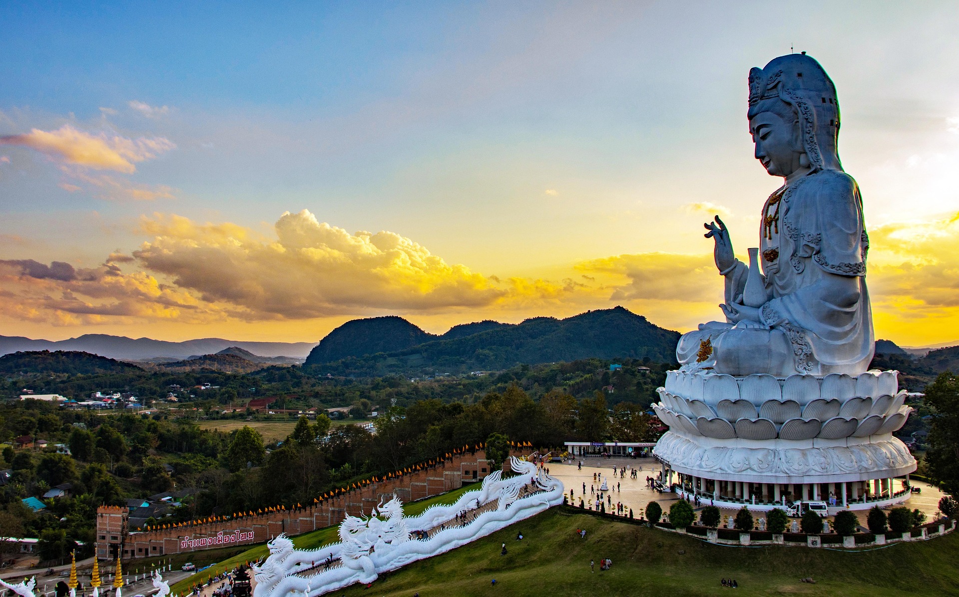 Die imposante weiße Statue von Wat Huai Pla Kung bei Chiang Rai erhebt sich eindrucksvoll vor sanften, grünen Hügeln. Das buddhistische Wahrzeichen im Norden Thailands zieht Besucher mit seiner spirituellen Ausstrahlung und malerischen Lage an.